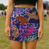High-waisted fitted mini skirt featuring a vibrant tiger print in rainbow colors over a blue and purple camouflage background. The skirt includes a 1.5” elastic waistband and is made of eco polyester and spandex. Pencil fit hugs the body with a smooth silhouette. Available in performance or glitter finish, sizes S to XL.